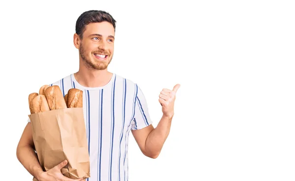 Handsome Young Man Bear Holding Paper Bag Bread Pointing Thumb — Stock Photo, Image