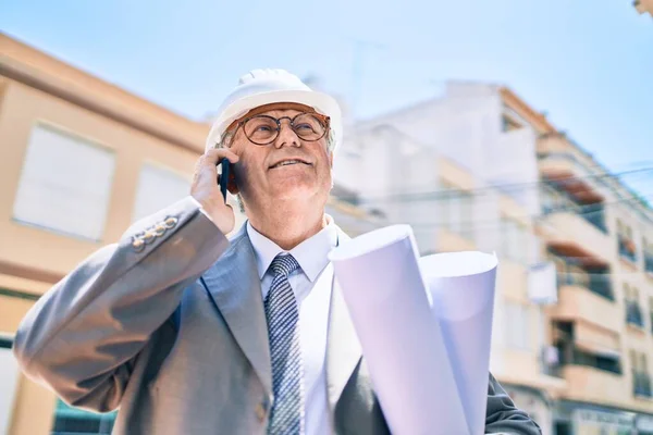 Senior Uomo Architetto Dai Capelli Grigi Possesso Cianografie Utilizzando Smartphone — Foto Stock