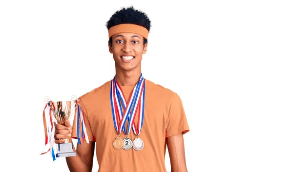 Jovem Afro Americano Segurando Troféu Campeão Vestindo Medalhas Olhando Positivo — Fotografia de Stock