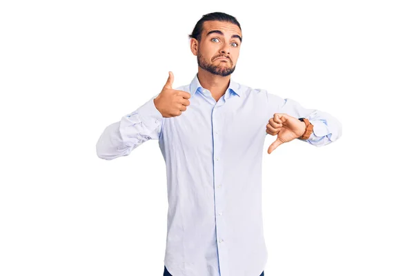 ビジネス服を着た若いハンサムな男が親指を上下に 意見の相違および一致の表現をしている 狂気の葛藤 — ストック写真