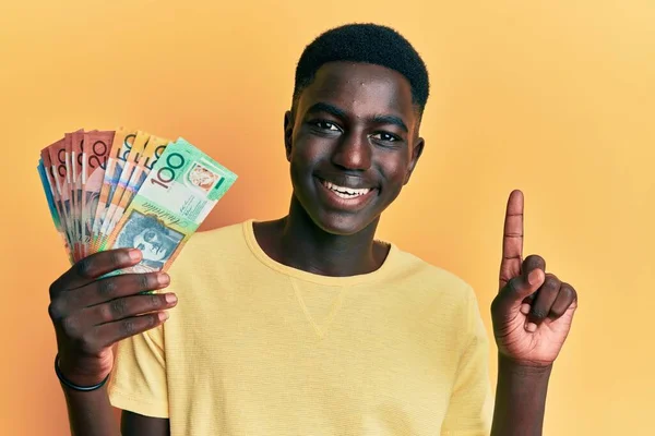 Fiatal Afro Amerikai Férfi Ausztrál Dollárral Kezében Mosolyog Egy Ötlettel — Stock Fotó