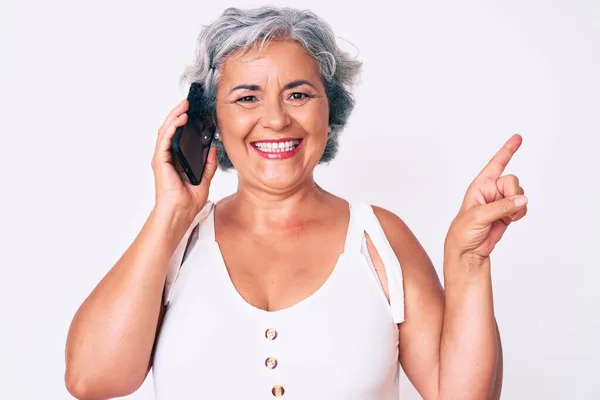 笑顔で話している会話を持っているシニアヒスパニック系白髪の女性側に手と指で幸せなポインティング — ストック写真