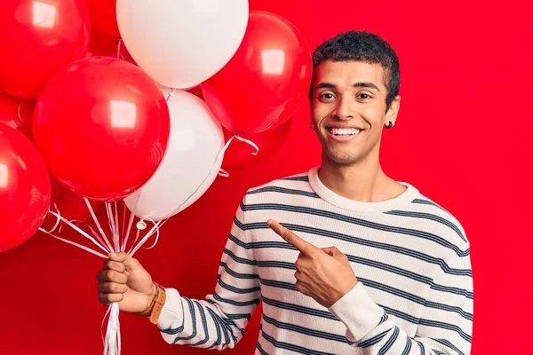 Ung Afrikansk Amercian Man Håller Ballonger Ler Glad Pekar Med — Stockfoto