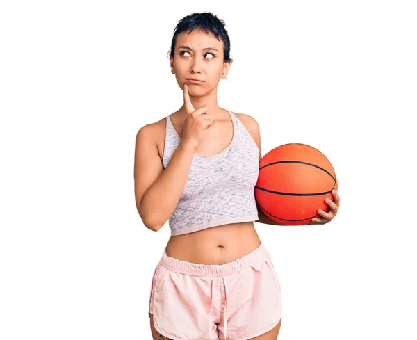 Jovem Mulher Segurando Bola Basquete Rosto Sério Pensando Questão Com — Fotografia de Stock