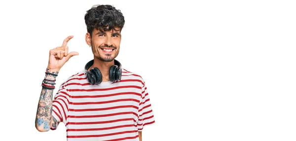 Joven Hombre Hispano Escuchando Música Usando Auriculares Sonrientes Con Gesto —  Fotos de Stock