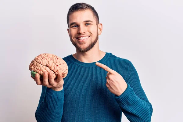 Beyni tutan yakışıklı genç adam gülümsüyor. 