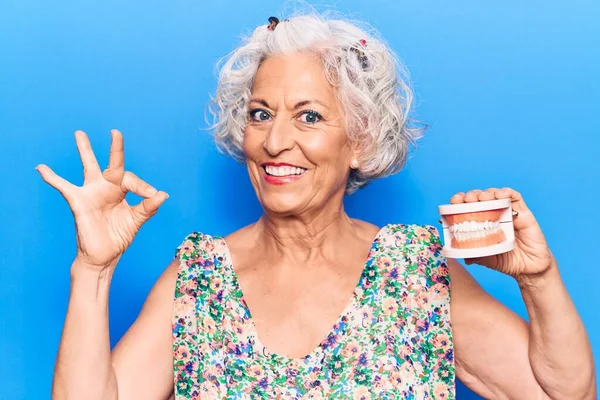 Senior Grauhaarige Frau Mit Gebiss Tut Zeichen Mit Den Fingern — Stockfoto