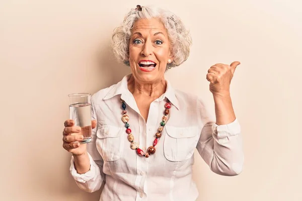 Senior Mulher Cabelos Grisalhos Beber Copo Água Apontando Polegar Até — Fotografia de Stock