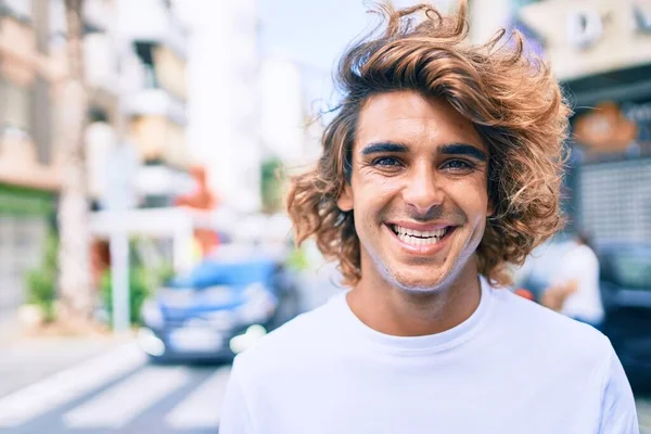 Genç, yakışıklı, gülümseyen bir İspanyol. Şehrin caddesinde mutlu bir şekilde yürüyor.