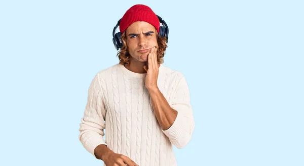 Young Hispanic Man Listening Music Using Headphones Touching Mouth Hand — Stock Photo, Image