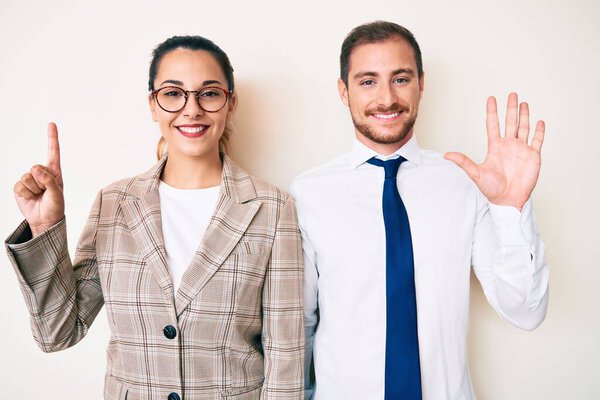 Beautiful couple wearing business clothes showing and pointing up with fingers number six while smiling confident and happy. 