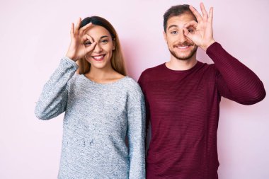 Gündelik kıyafetler giyen güzel bir çift el hareketleriyle gülümsüyor, gözleriyle mutlu yüzlere bakıyor.. 