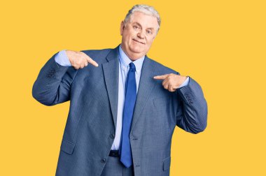 Kıdemli gri saçlı, iş ceketi giyen, kendine güvenen, gülümseyen, kendini gururlu ve mutlu gösteren bir adam.. 