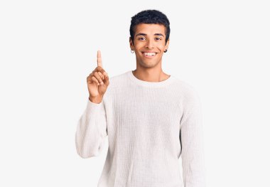 Gündelik giysiler giymiş genç Afro-Amerikan bir adam başarılı bir fikirle işaret ediyor. Heyecanlı ve mutlu. Bir numara.. 