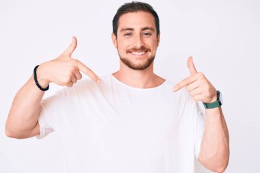 Genç, yakışıklı, günlük beyaz tişört giyen, kendine güvenen, gülümseyen, kendini gururlu ve mutlu gösteren bir adam.. 