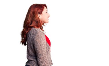 Genç, güzel, kızıl saçlı, sıradan bir kazak giyen, kendine güvenen bir gülümsemesi olan, rahat bir görünüm takınan bir kadın.. 