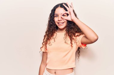 Güzel kız, kıvırcık saçlı, günlük kıyafetler giymiş, gülümseyen, mutlu, el pençe divan duran. 