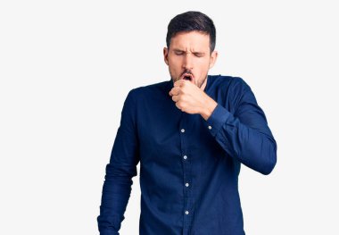 Rahat gömlekler giyen genç yakışıklı adam kendini iyi hissetmiyor ve soğuk algınlığı veya bronşitin belirtisi olarak öksürüyor. sağlık hizmeti kavramı. 