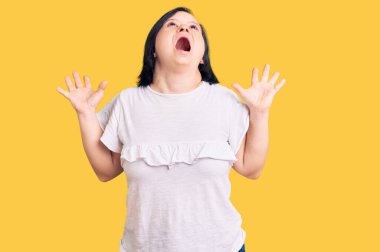 Down sendromlu esmer kadın, sıradan beyaz tişörtler giyip başarının çılgınlığını kutluyor. Kolları havada, gözleri kapalı, heyecanla bağırıyor. Kazanan konsept 