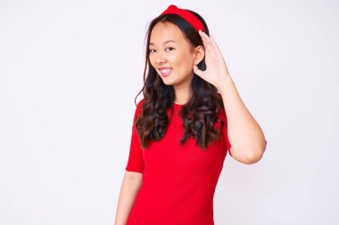 Genç, güzel Çinli bir kız. Günlük giysiler giymiş. Kulaktan kulağa gülümseyen ve dedikoduları ve dedikoduları dinleyen. Sağırlık kavramı. 