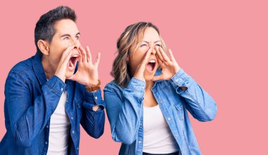 Sıradan kıyafetler giyen bir çift kadın elleri ağızda bağırarak bağırıyor. 