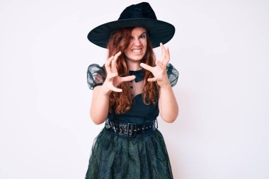 Cadı cadılar bayramı kostümü giymiş genç ve güzel bir kadın öfkeyle bağırıyor, elleri boğazlamaya çalışıyor, deli gibi bağırıyor 