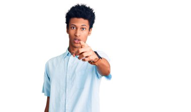 Genç, Afro-Amerikan bir adam, gündelik giysiler içinde kameraya kızgın ve hayal kırıklığına uğramış bir şekilde bakıyor. 