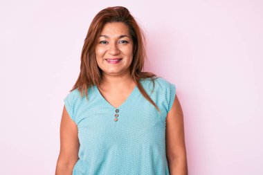 Orta yaşlı esmer, İspanyol kadın mutlu ve havalı bir gülümseme takınıyor. şanslı kişi. 