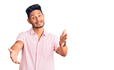 Yakışıklı Latin Amerikalı sıradan bir yaz gömleği giyen genç adam kameraya sarılıp gülümsüyor. Mutluluğu kucaklayan neşeli bir ifade.. 