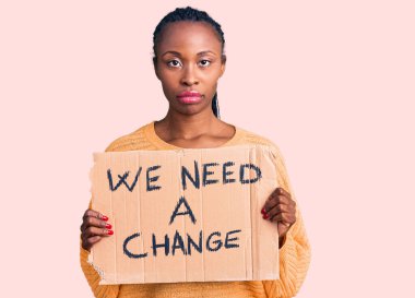 Genç Afro-Amerikalı bir kadının elinde bir değişim bayrağına ihtiyacımız var. Düşünce tarzı ve ayık ifadesi. Kendine güveni tam görünüyor. 
