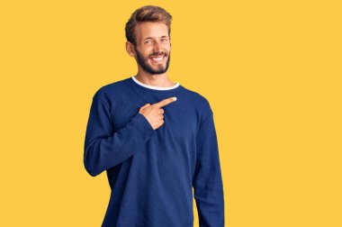 Sakallı, sıradan süveter giyen yakışıklı, endişeli, endişeli ve şaşırmış bir adam. 