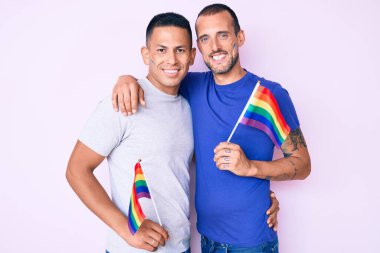 Birbirine aşık genç eşcinsel çiftler eşcinsellerin gururlu bayrağını taşıyor.