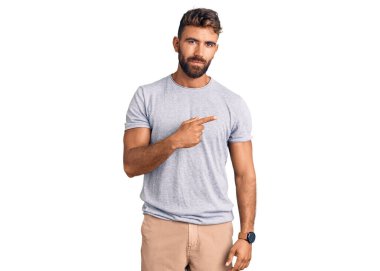 Gündelik giysiler giymiş genç İspanyol bir adam el ile işaret ediyor. Ciddi ve sakin bir yüz ifadesi sergiliyor. 