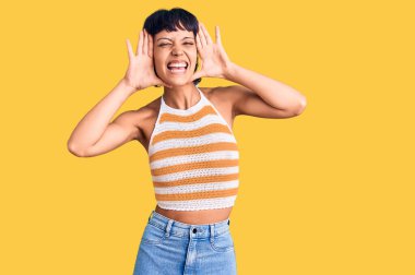 Kısa saçlı, sıradan kıyafetler giyen, neşeli gülümseyen, elleri ve yüzü görünen genç esmer kadın. Şaşırdım ve çıktım. 