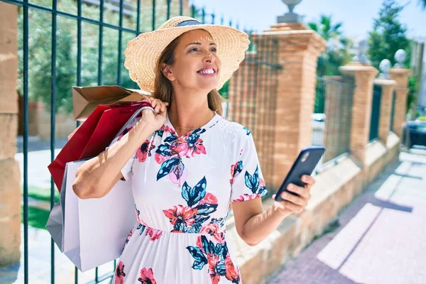 Medelålders Kvinna Som Håller Shoppingväskor Och Använder Smartphone Staden — Stockfoto