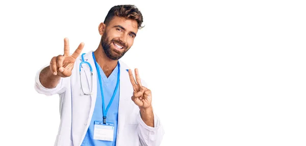 Joven Hispano Vistiendo Uniforme Médico Estetoscopio Sonriendo Mirando Cámara Mostrando —  Fotos de Stock