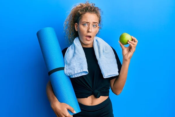 Güzel Beyaz Bir Kız Elinde Yoga Minderi Yeşil Elmayla Şaşkın — Stok fotoğraf