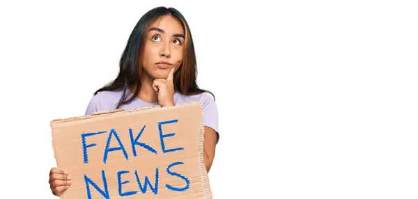 Jonge Latijnse Vrouw Met Nep Nieuws Banner Serieus Gezicht Denken — Stockfoto