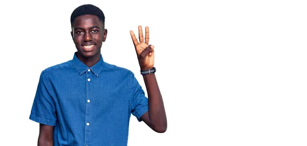 自信を持って幸せな笑みを浮かべている間 若いアフリカ系アメリカ人の男性は カジュアルな服を着て指の数3で示すと指摘 — ストック写真