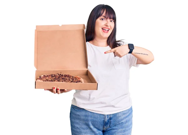 Młody Rozmiar Kobieta Trzyma Pudełko Pizzy Uśmiechając Szczęśliwy Wskazując Ręką — Zdjęcie stockowe