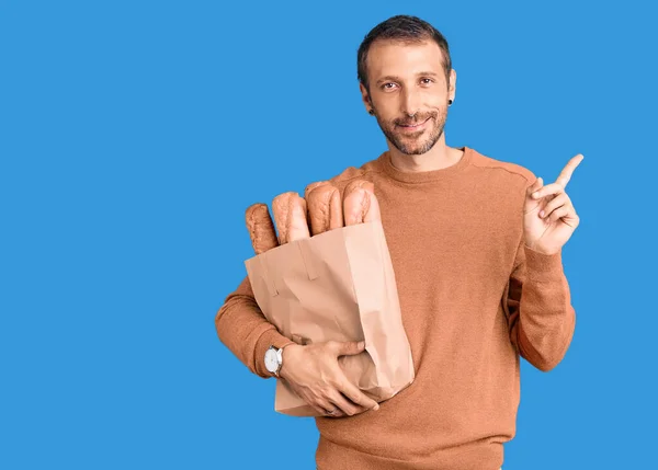 Jovem Homem Bonito Segurando Saco Papel Com Pão Sorrindo Feliz — Fotografia de Stock