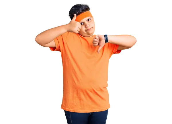 スポーツウェアを身に着けている小さな男の子は親指を上下に 意見の相違および一致の表現をする 狂気の葛藤 — ストック写真