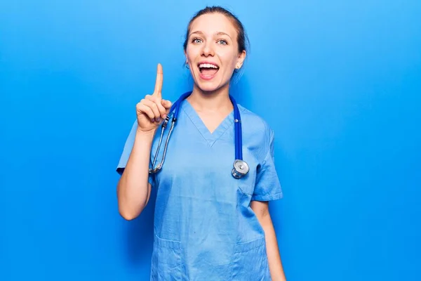 Mladá Blondýnka Doktorské Uniformě Stetoskopu Ukazuje Prstem Nahoru Úspěšným Nápadem — Stock fotografie