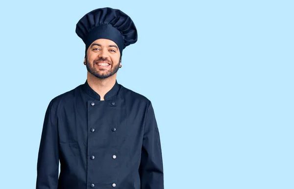 Joven Hombre Hispano Con Uniforme Cocina Con Una Sonrisa Alegre —  Fotos de Stock
