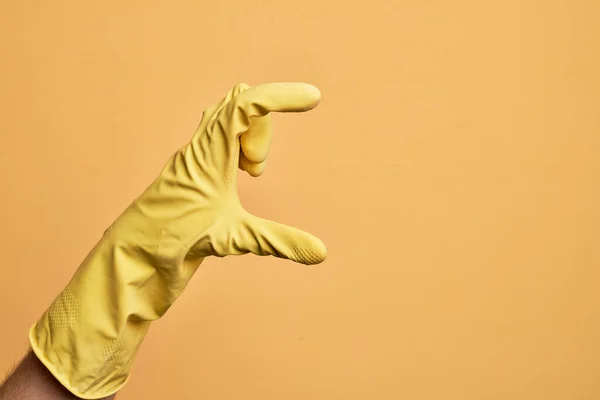 Ręka Białego Młodzieńca Rękawicą Czyszczącą Nad Odizolowanym Żółtym Tłem Zbierającym — Zdjęcie stockowe