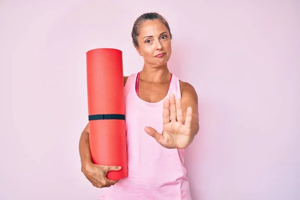 Orta Yaşlı Spanyol Kadın Elinde Yoga Minderiyle Elinde Dur Işareti — Stok fotoğraf