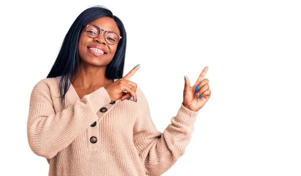 若いアフリカ系アメリカ人の女性は カジュアルな服を着て笑顔とカメラを見て2本の手と指で側面を指して — ストック写真