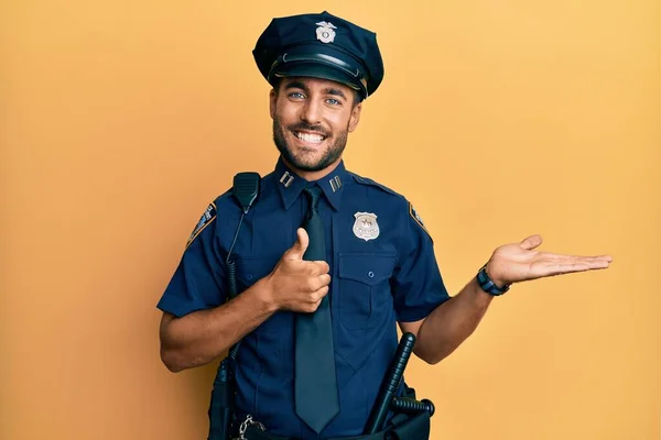 Snygg Hispanic Man Bär Polisuniform Visar Handflatan Och Gör Gest — Stockfoto