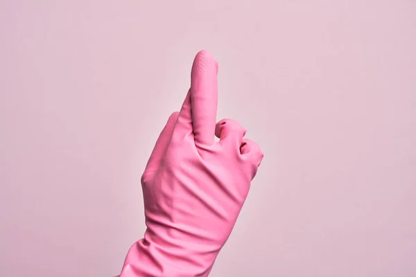 在孤立的粉色背景下 手里拿着清洁手套的高加索年轻人交叉着手指 迷信和幸运的手势 幸运和希望的表情 — 图库照片