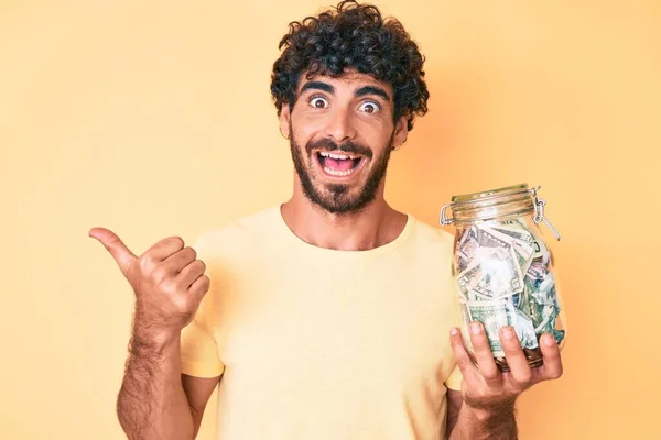 Handsome Young Man Curly Hair Bear Holding Jar Savings Pointing — Stock Photo, Image